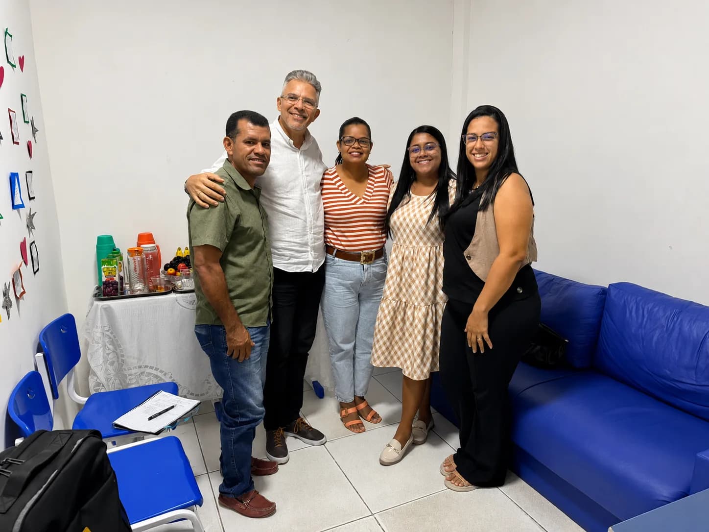 Reunião de articulação com equipe escolar em sala com mobiliário azul