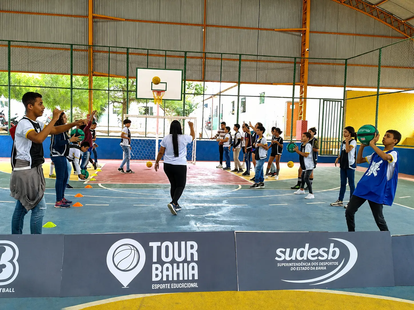 Estudantes participam de clínica esportiva do Tour Bahia em uma quadra escolar