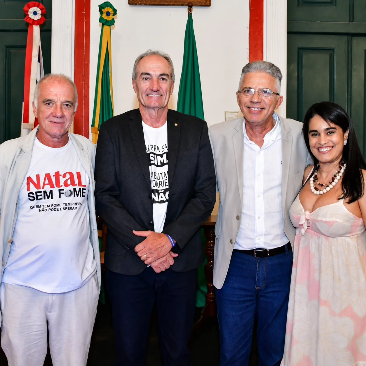 Registro institucional em evento cívico, com bandeiras ao fundo